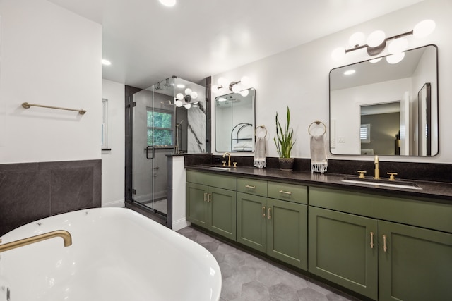 bathroom featuring double vanity, a freestanding bath, a shower stall, and a sink
