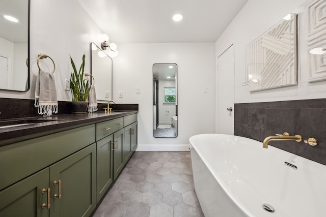 bathroom featuring double vanity, tile patterned floors, a sink, and a soaking tub