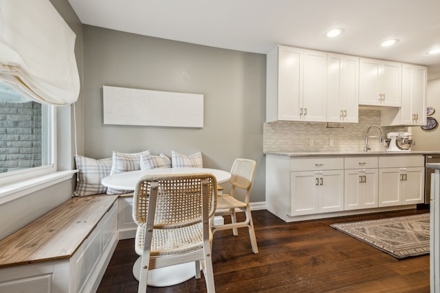 kitchen with decorative backsplash, white cabinets, and dark wood-style flooring