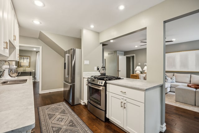 kitchen featuring dark wood-style floors, recessed lighting, white cabinets, a sink, and appliances with stainless steel finishes
