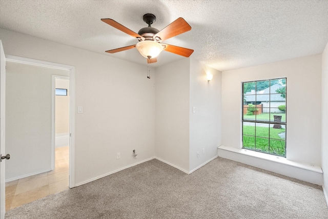 unfurnished room with carpet flooring, a ceiling fan, a textured ceiling, and baseboards