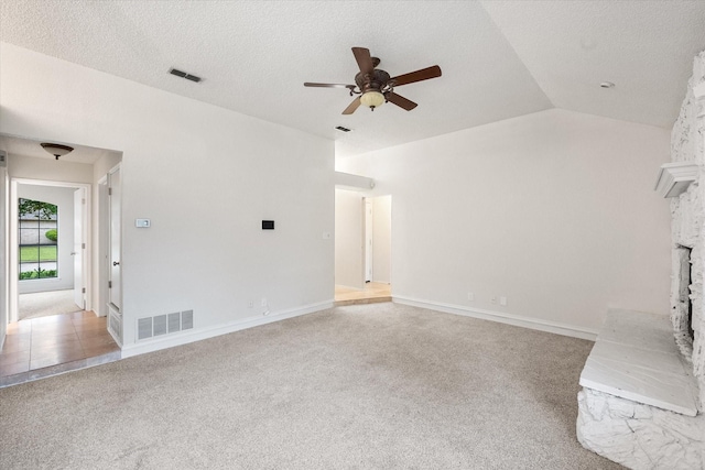 unfurnished living room featuring visible vents, a ceiling fan, carpet floors, and vaulted ceiling