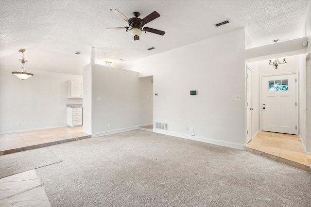 unfurnished living room featuring ceiling fan, light colored carpet, a textured ceiling, and visible vents