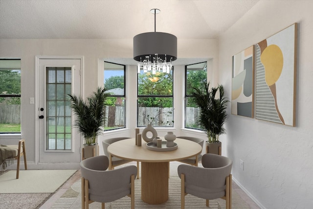 dining area with baseboards, a notable chandelier, and a wealth of natural light