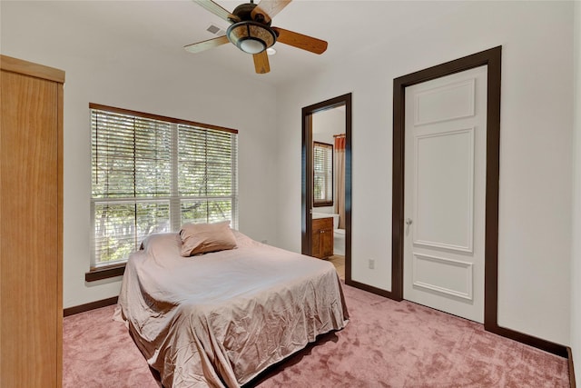bedroom with light colored carpet, baseboards, ensuite bathroom, and ceiling fan