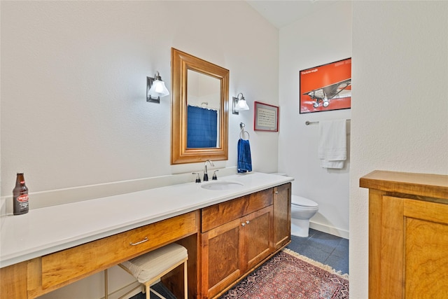 bathroom featuring toilet, tile patterned floors, baseboards, and vanity