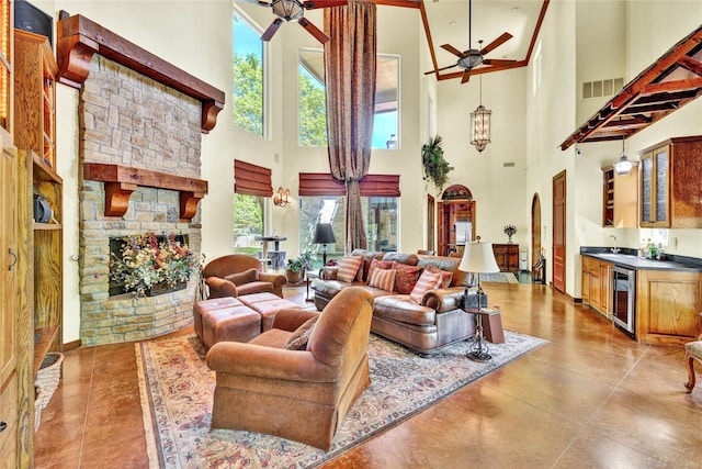 living room featuring beverage cooler, a ceiling fan, and a towering ceiling