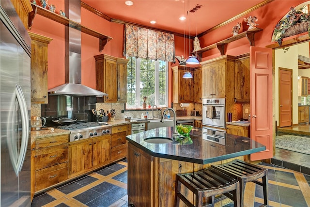 kitchen featuring wall chimney range hood, backsplash, brown cabinets, ornamental molding, and stainless steel appliances