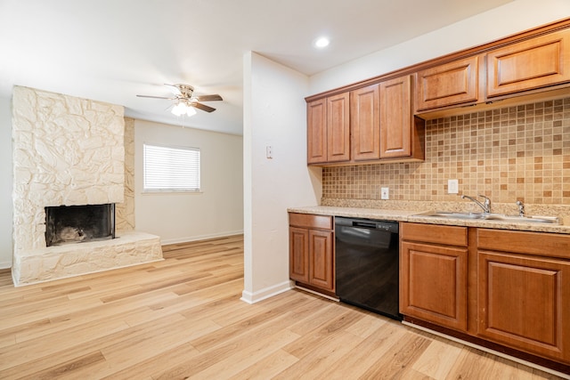 kitchen featuring brown cabinets, a sink, black dishwasher, a ceiling fan, and decorative backsplash