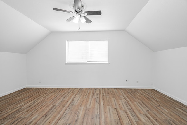 additional living space featuring baseboards, ceiling fan, wood finished floors, and vaulted ceiling