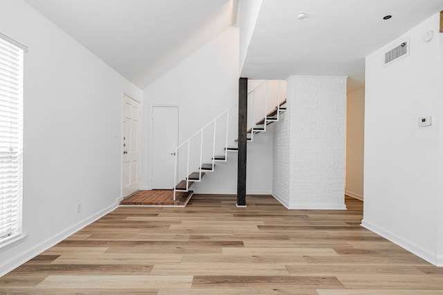 foyer featuring visible vents, light wood-style flooring, baseboards, and stairway