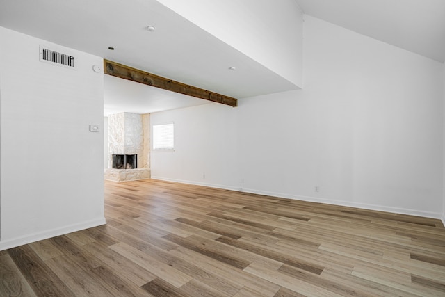 interior space with baseboards, visible vents, light wood finished floors, and a fireplace