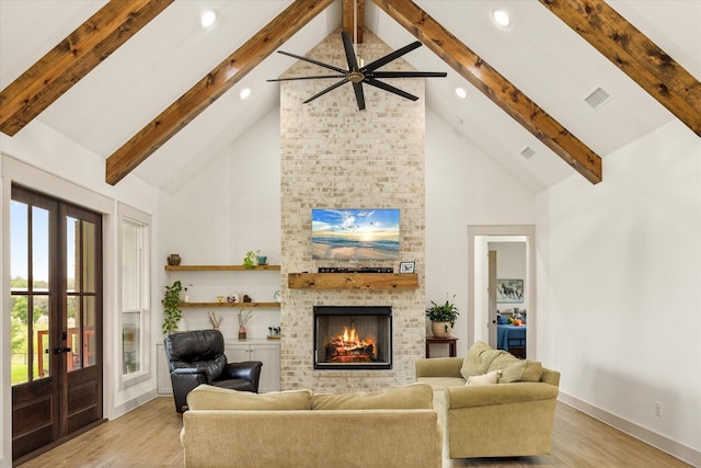 living room featuring high vaulted ceiling, french doors, light wood finished floors, and a fireplace