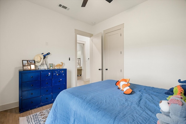bedroom featuring light wood-style floors, baseboards, ceiling fan, and visible vents