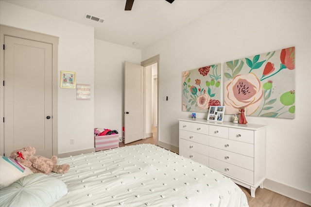 bedroom with light wood-style floors, baseboards, ceiling fan, and visible vents