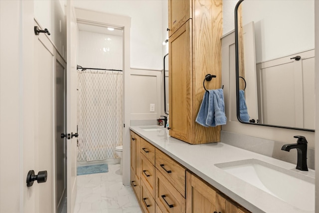 full bath featuring double vanity, a sink, marble finish floor, and toilet