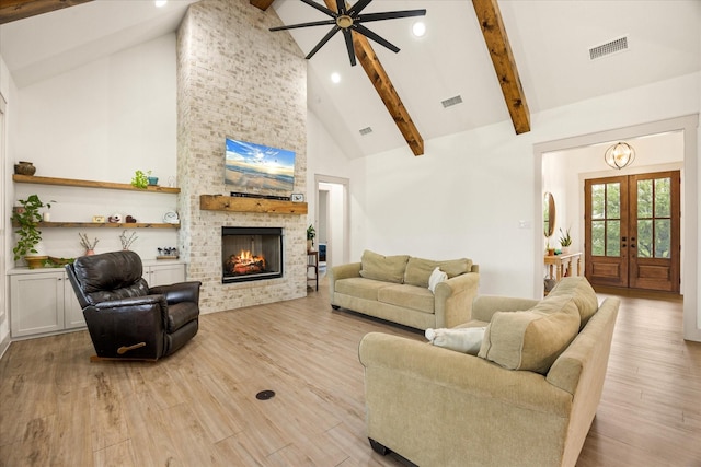 living room with ceiling fan, visible vents, a fireplace, beam ceiling, and high vaulted ceiling