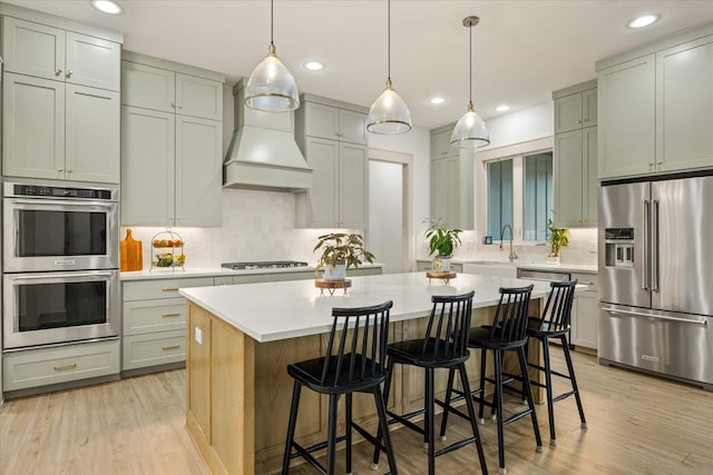 kitchen featuring appliances with stainless steel finishes, tasteful backsplash, a kitchen island, and custom exhaust hood
