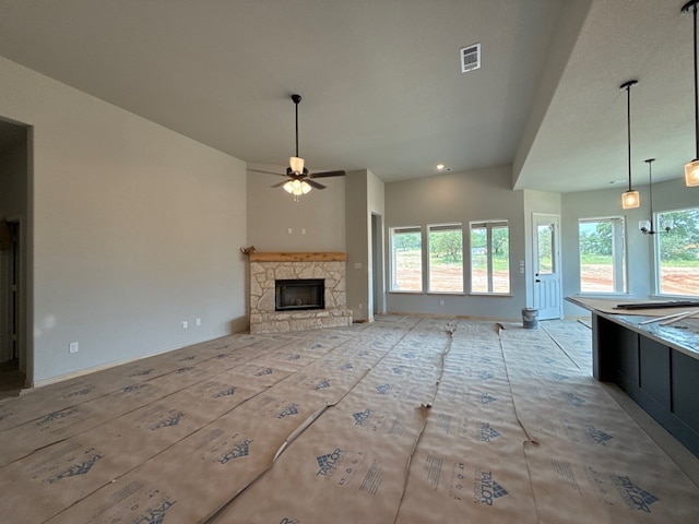 505 Ashlow Ct, Springtown, TX 76082 - unfurnished living room featuring ceiling fan, a stone fireplace, and baseboards
