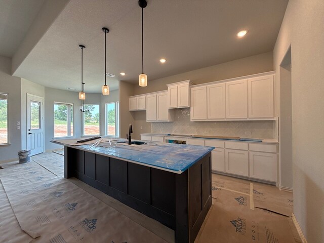 505 Ashlow Ct, Springtown, TX 76082 - kitchen with a sink, tasteful backsplash, a large island with sink, white cabinets, and baseboards