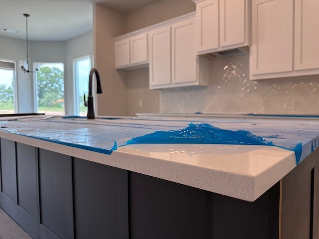 505 Ashlow Ct, Springtown, TX 76082 - kitchen with a center island, light stone counters, white cabinets, and backsplash