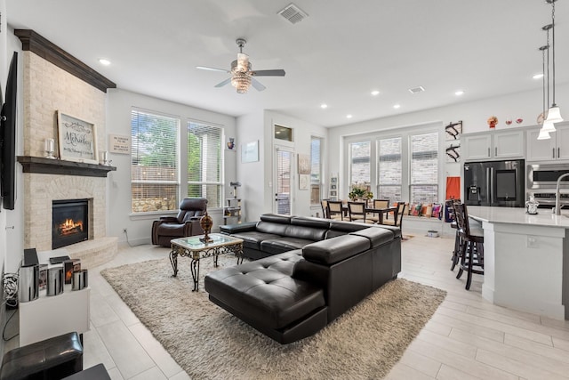 living area with visible vents, a ceiling fan, recessed lighting, and a fireplace