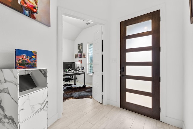 entrance foyer with light wood-style flooring and lofted ceiling