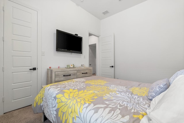 carpeted bedroom with vaulted ceiling and visible vents