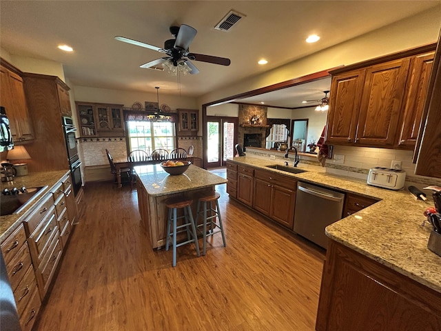284 County Road 2388, Pickton, TX 75471 - kitchen featuring wood finished floors, a kitchen island, brown cabinets, a sink, and black appliances