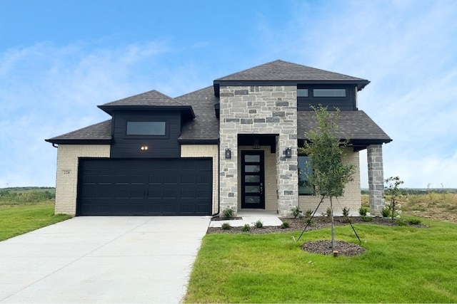 view of front of property with roof with shingles, an attached garage, stone siding, a front yard, and concrete driveway