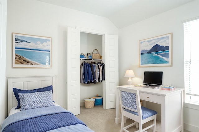 bedroom featuring baseboards, vaulted ceiling, light carpet, and a closet