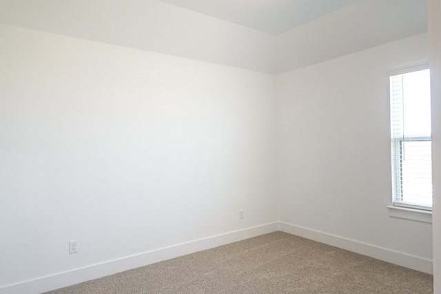 empty room featuring plenty of natural light, baseboards, and light carpet