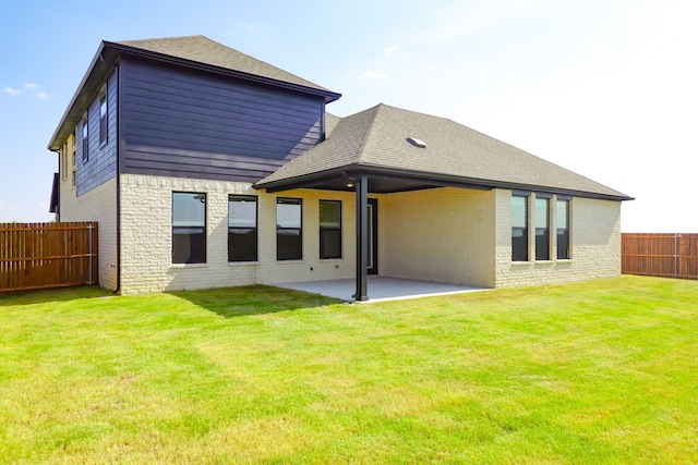 back of house with brick siding, a shingled roof, a fenced backyard, and a patio area