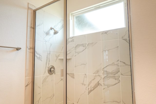 full bathroom with a marble finish shower