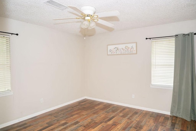 spare room with ceiling fan, a textured ceiling, baseboards, wood finished floors, and visible vents
