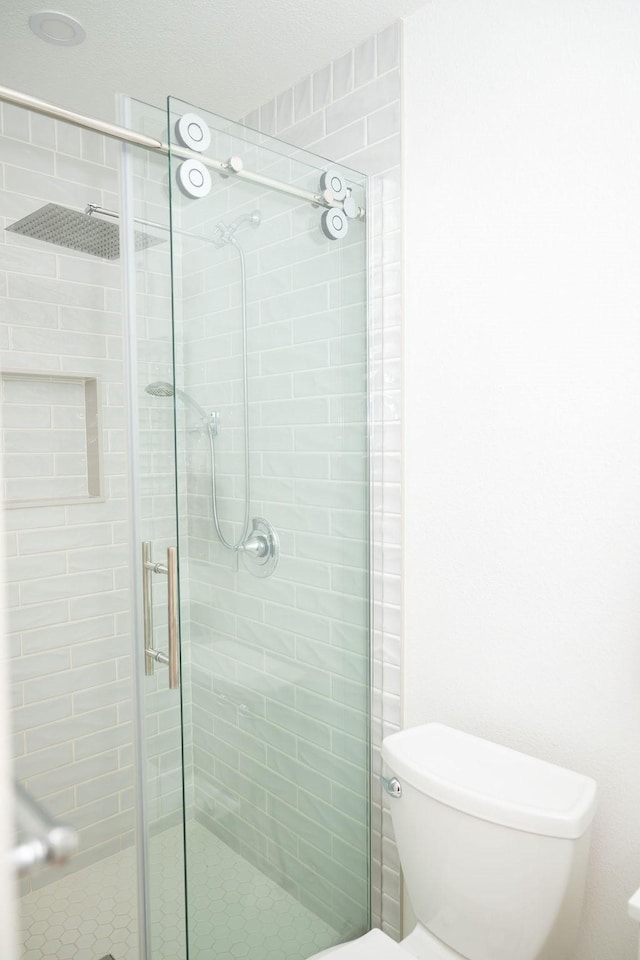 full bathroom featuring a stall shower and toilet