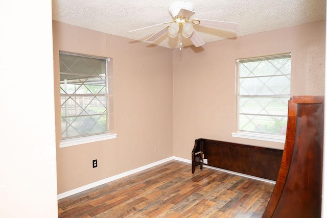 unfurnished room with a textured ceiling, plenty of natural light, and wood finished floors