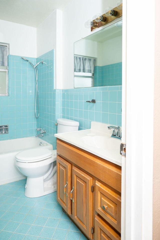 full bath with tile walls, shower / tub combination, tile patterned floors, vanity, and toilet