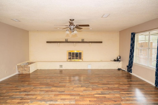 unfurnished room with baseboards, a textured ceiling, ceiling fan, and wood finished floors