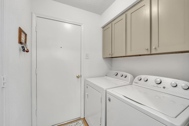 laundry area featuring a textured ceiling, cabinet space, and independent washer and dryer