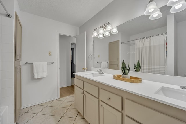 bathroom with a sink, a shower with curtain, tile patterned floors, and double vanity