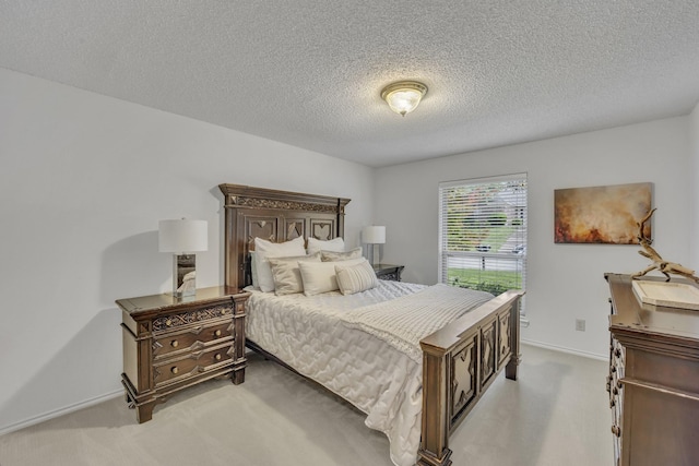 bedroom featuring baseboards, light carpet, and a textured ceiling