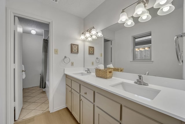 full bathroom featuring double vanity, a textured ceiling, a sink, and shower / tub combo with curtain