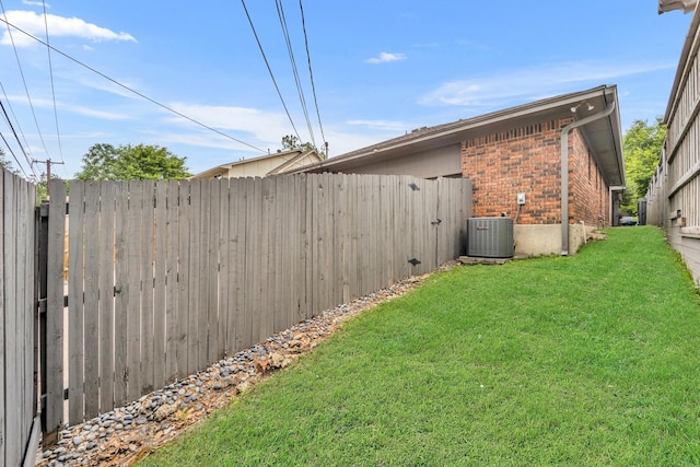 view of yard with fence and central AC