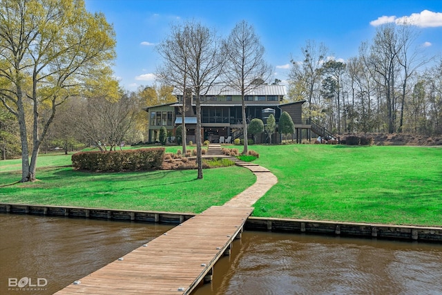 view of dock with a yard, a water view, and a balcony