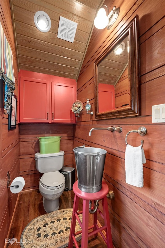 bathroom featuring visible vents, toilet, wooden ceiling, wood finished floors, and vaulted ceiling