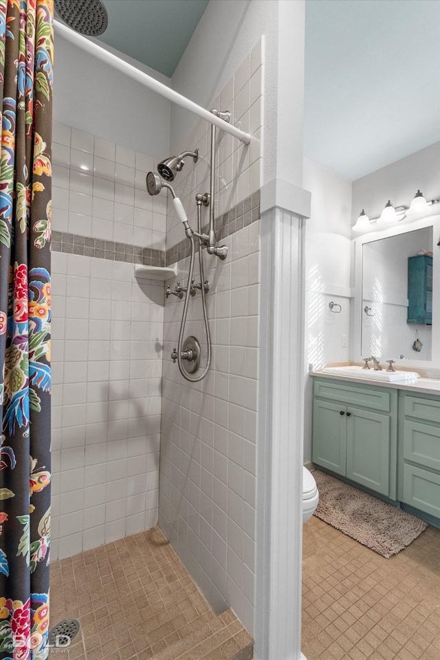 bathroom featuring vanity, toilet, and tiled shower