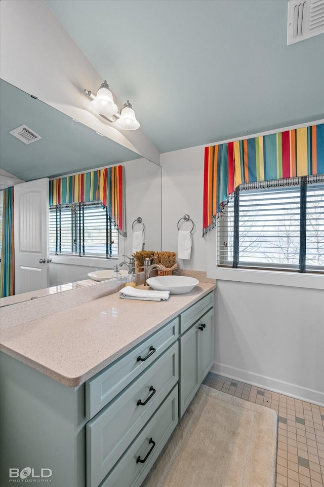 bathroom featuring baseboards, visible vents, and vanity