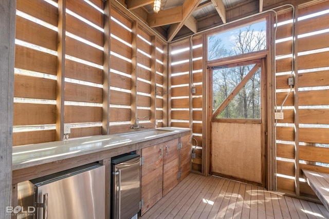 interior space with light wood-type flooring and wood walls