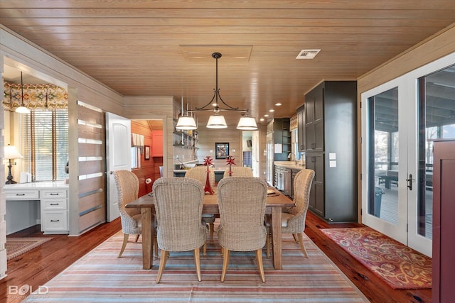 dining area featuring visible vents, wood ceiling, and wood finished floors